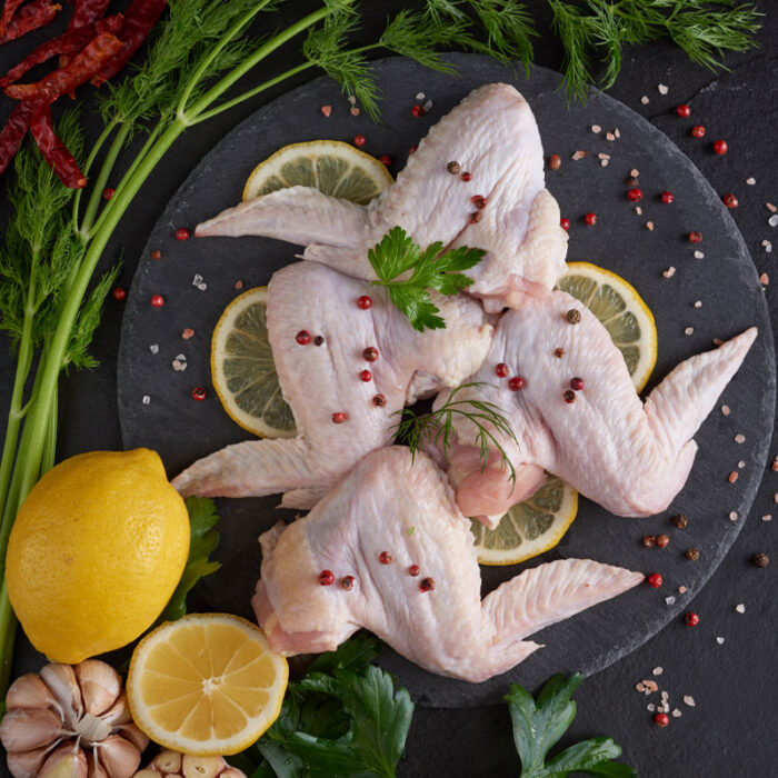 Raw chicken wings with ingredients for cooking. Raw meat. Chicke Ailes de poulet (le Kg) – Image 1